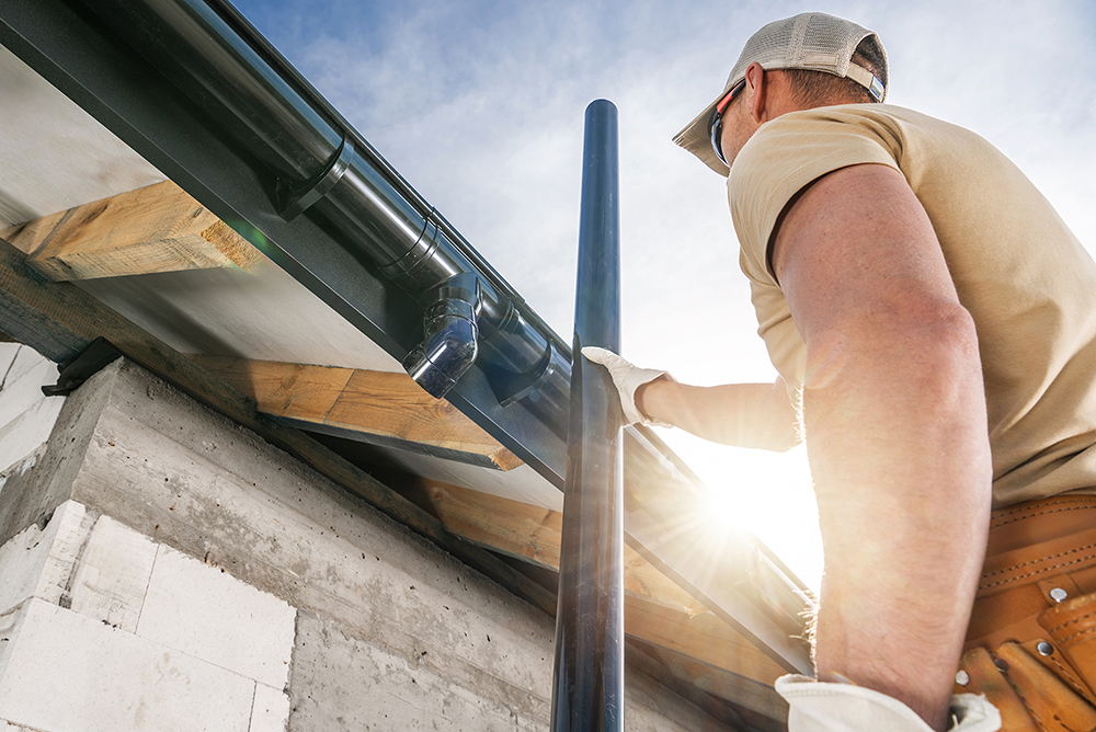 Worker installing new gutter on a property in London